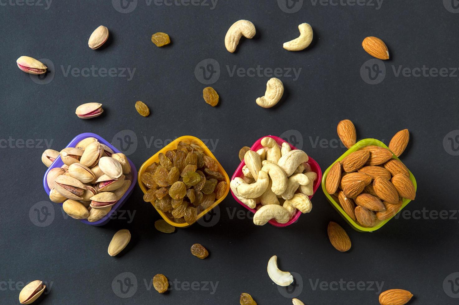 gezonde mix droog fruit en noten op donkere achtergrond. amandelen, pistache, cashewnoten, rozijnen foto