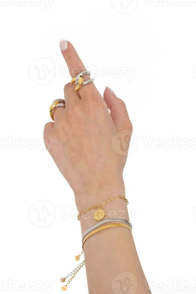 vrouw hand- vervelend vlinder en slang keten armbanden en met elkaar verbonden gouden en zilver ringen reeks tegen een wit achtergrond. mooi Valentijnsdag geschenk. foto