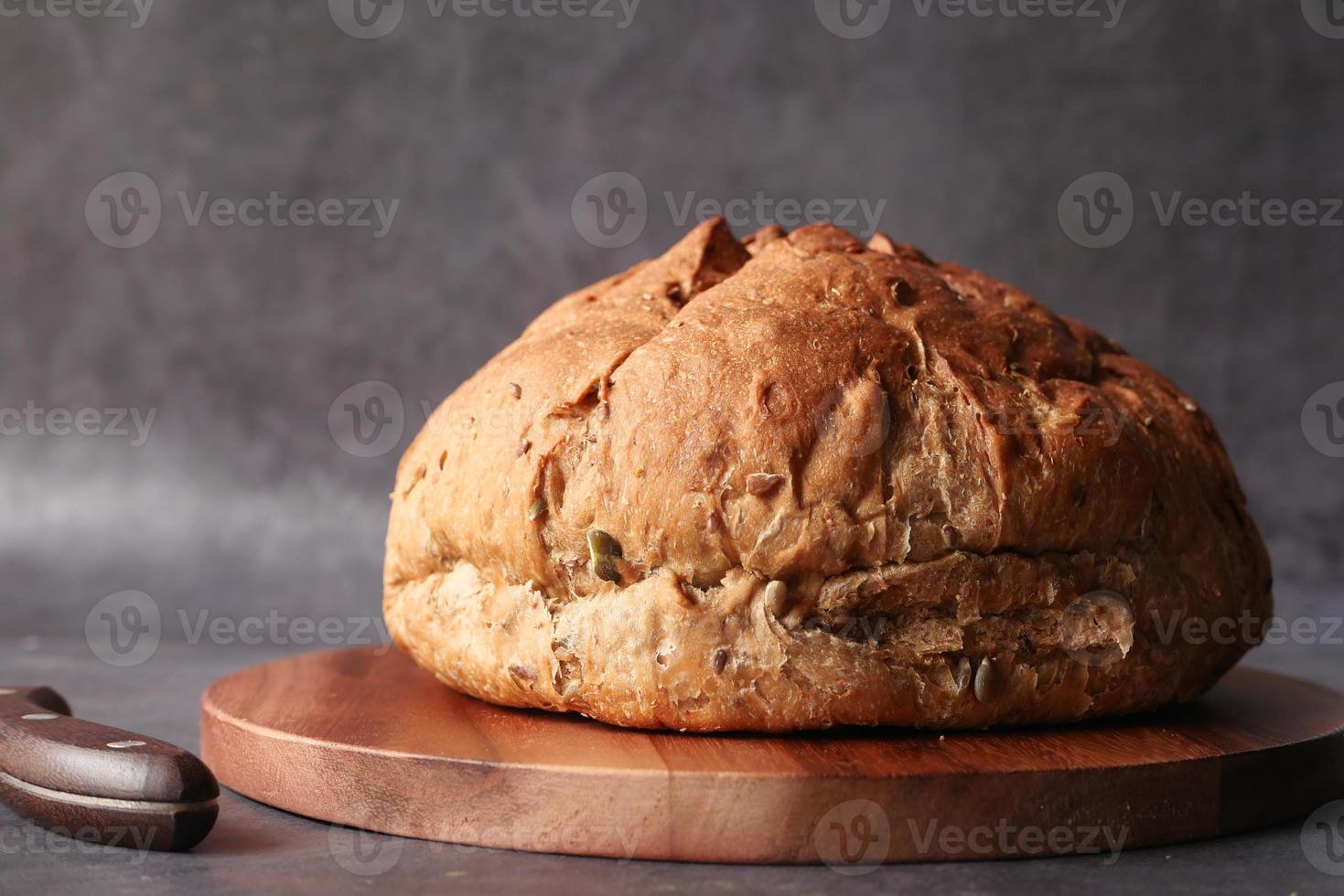 rond bruin gebakken brood op snijplank foto