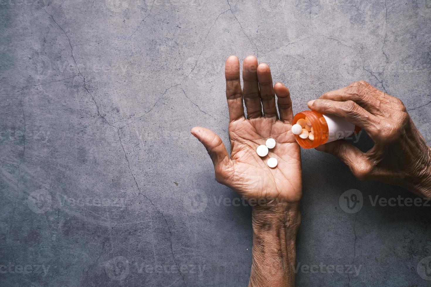 senior hand vasthouden met pillen op zwarte achtergrond met kopie ruimte foto