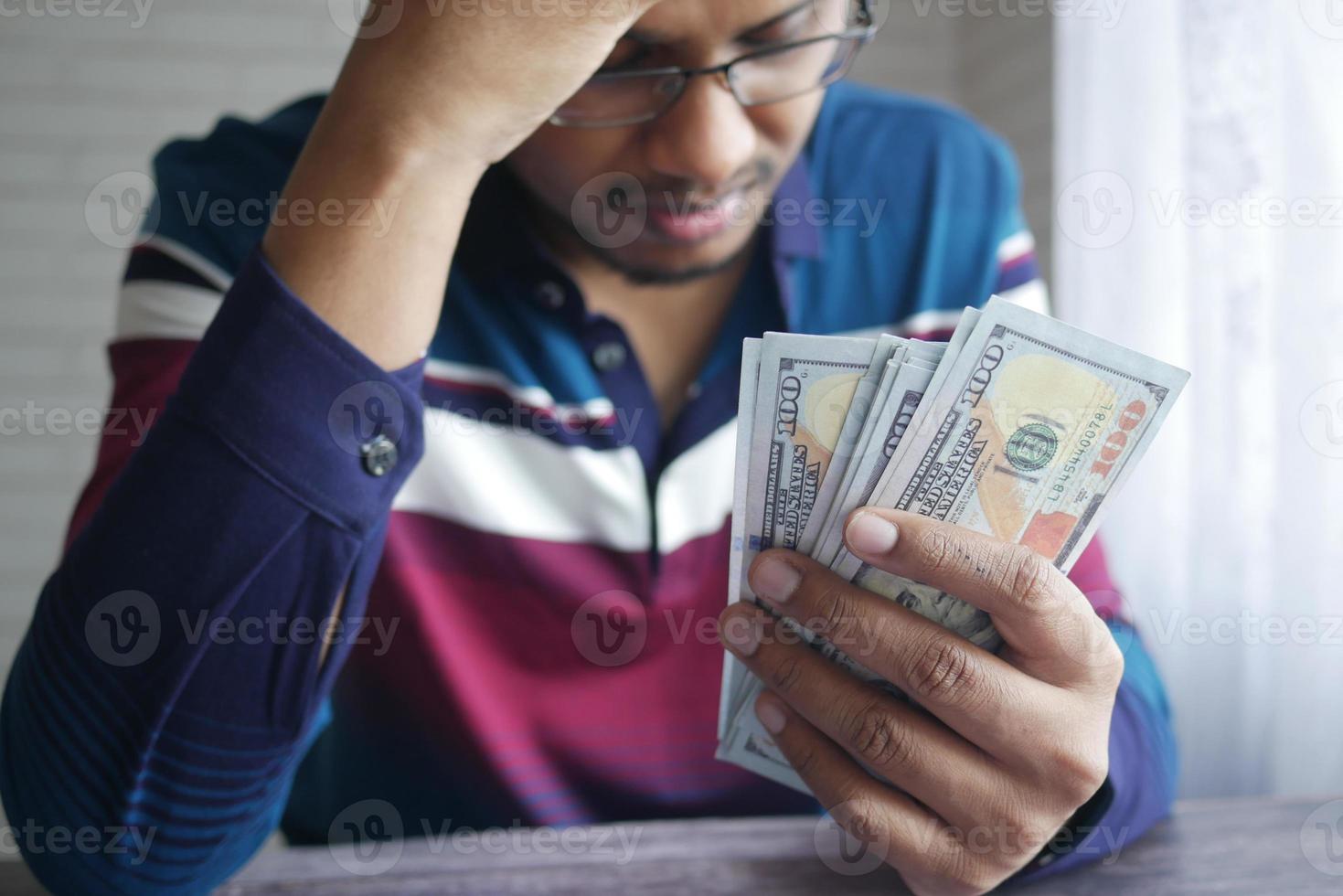 overstuur man hand met 100 dollar contant geld foto