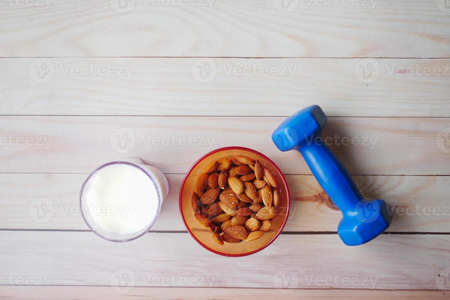 amandelnoot in een kom, melk en halter op tafel foto