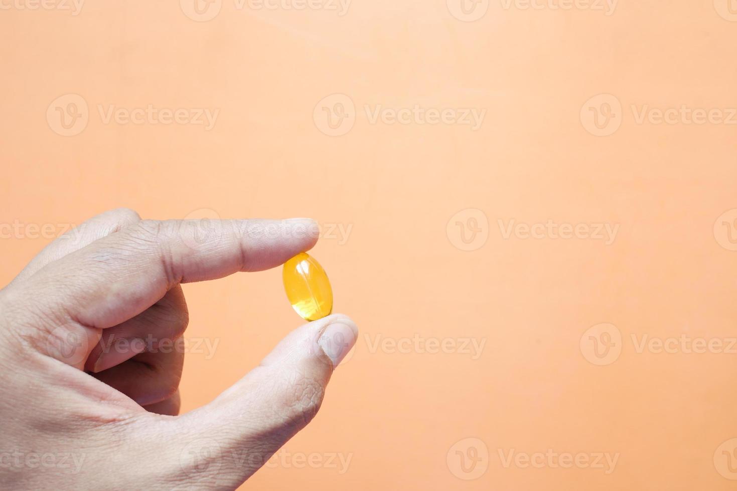 met visoliesupplement op oranje achtergrond foto