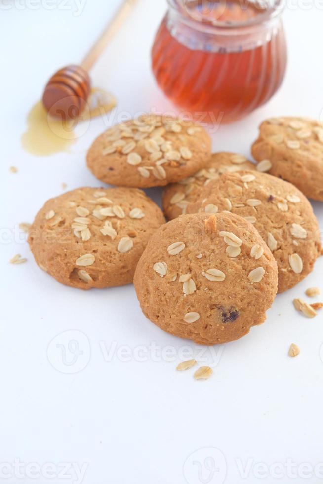 stapel hele maaltijdkoekjes en honing op houten achtergrond foto