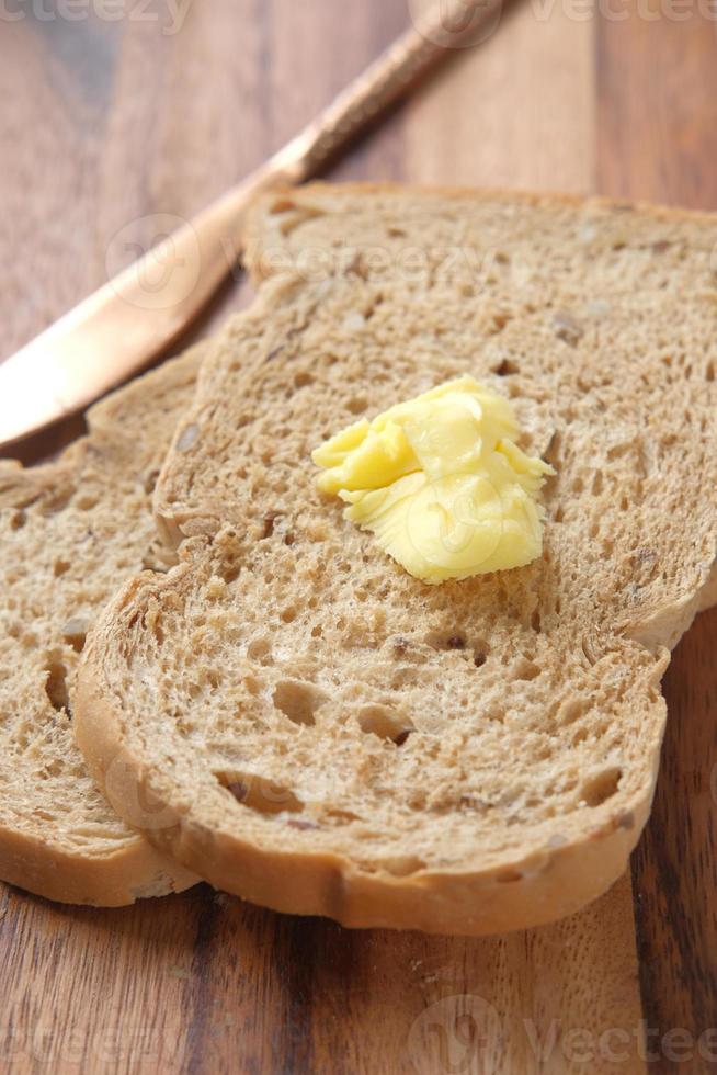 plakje boter en volkorenbrood op snijplank chop foto