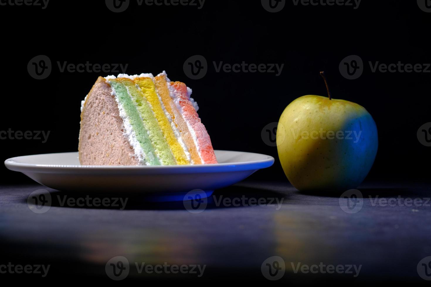 groene appel en een bakkerijcake op zwarte achtergrond foto