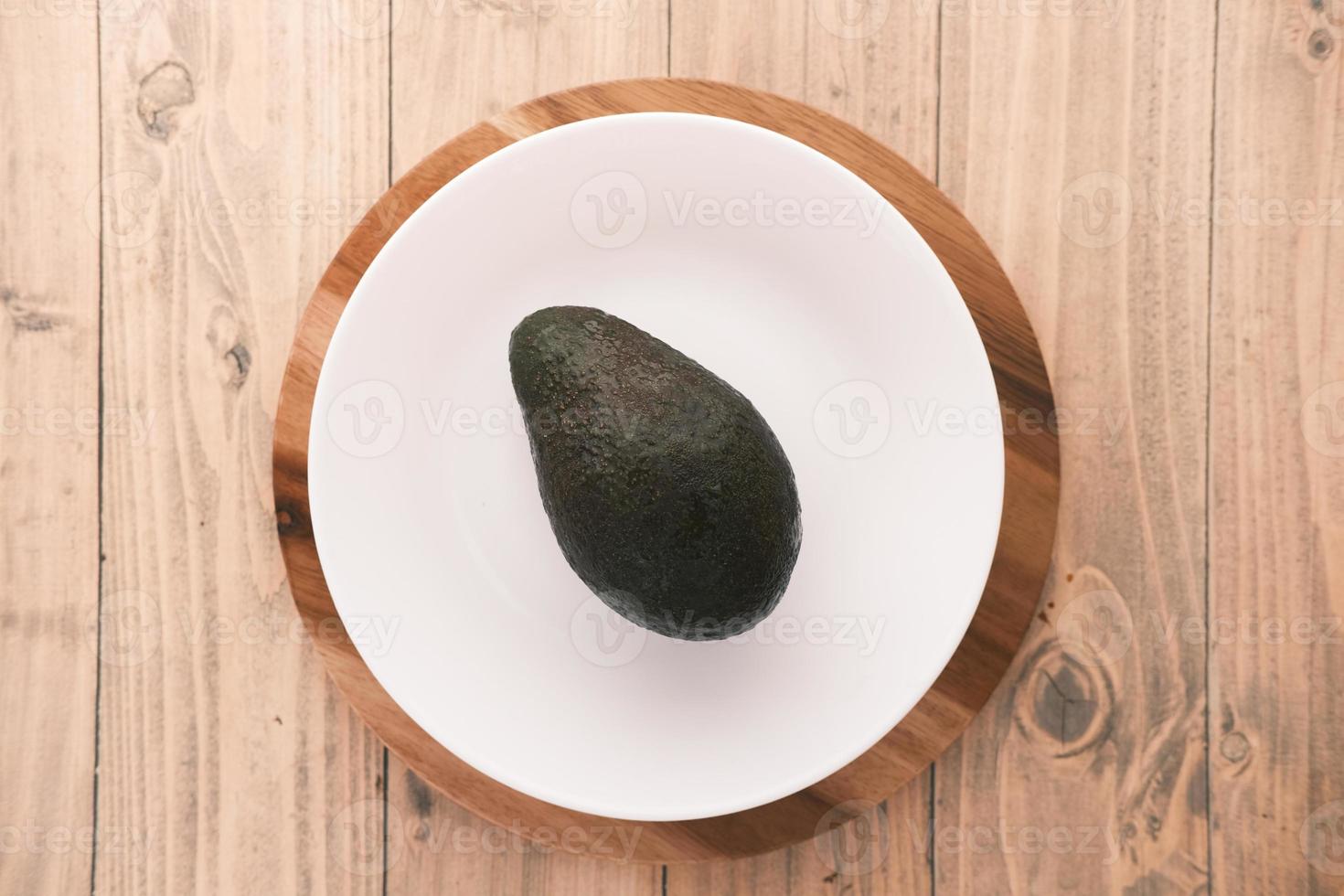 bovenaanzicht van plakje avocado op een bord op houten tafel foto