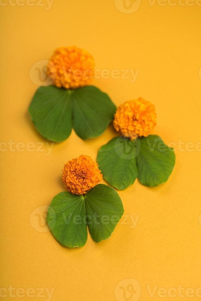 indiase festival dussehra, met gouden blad bauhinia racemosa en goudsbloem bloemen op een gele achtergrond. foto