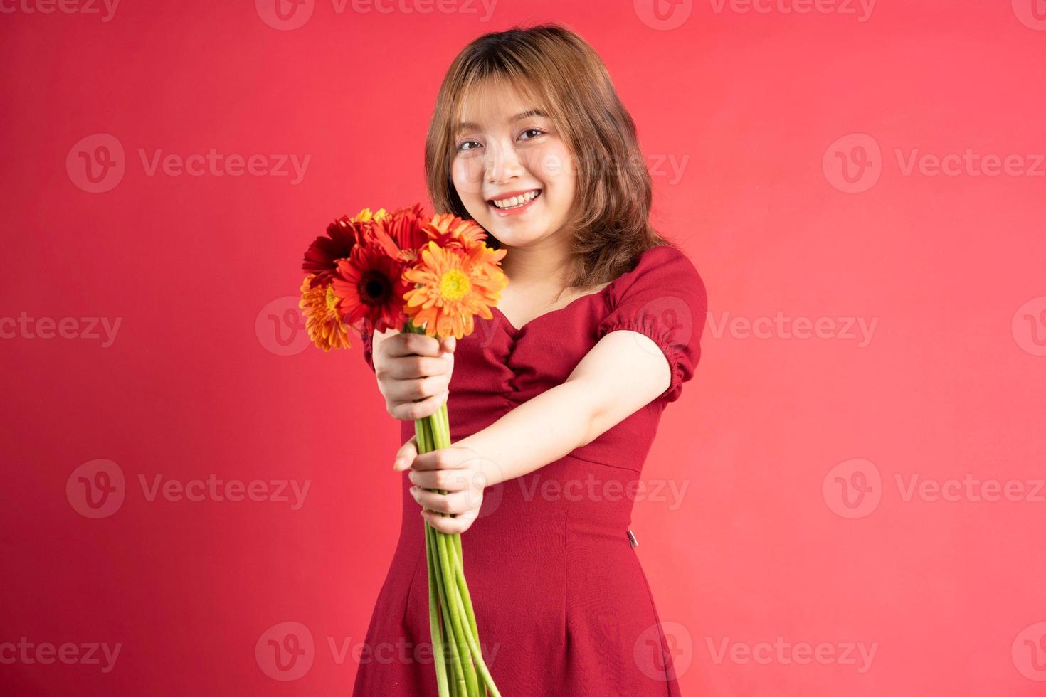 jong meisje met een boeket gerbera's met een vrolijke uitdrukking op de achtergrond foto