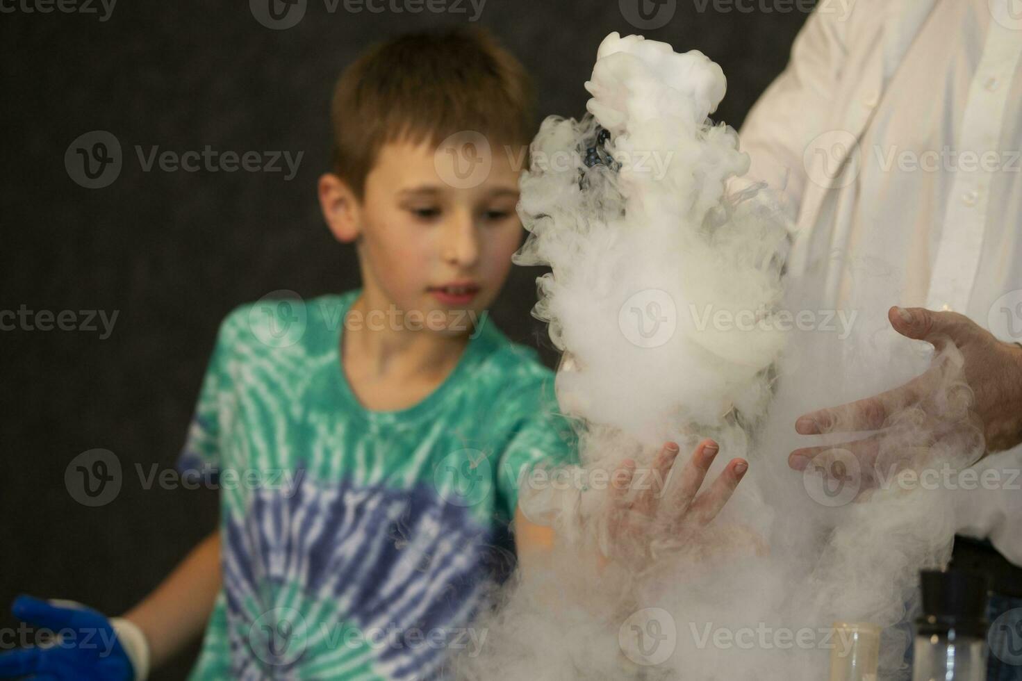de jongen voert een wetenschappelijk chemisch experiment met vloeistof stikstof. foto