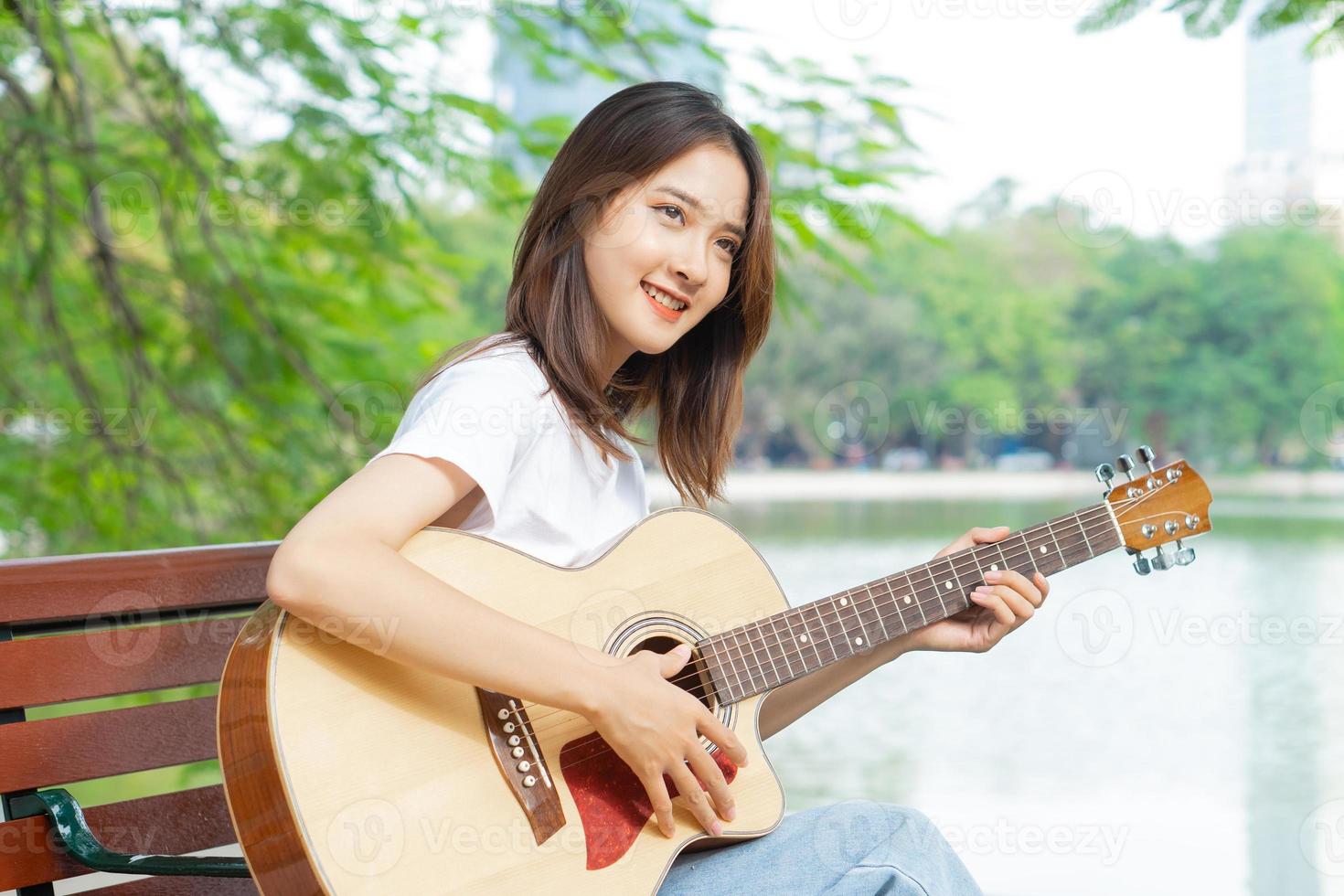 aziatische vrouw die gitaar speelt op straat foto