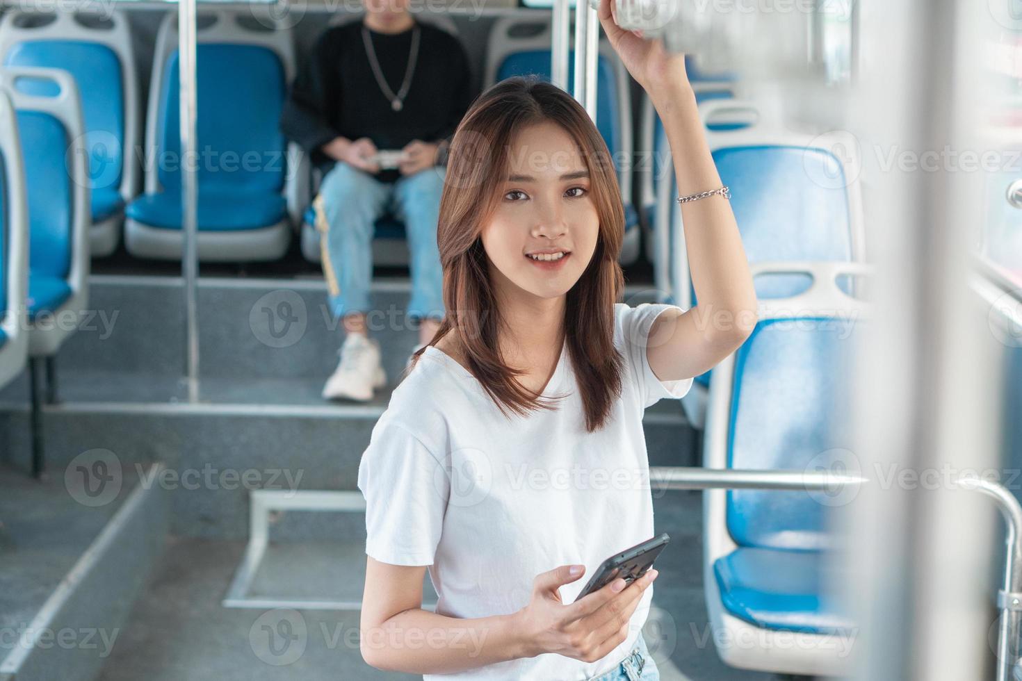 aziatische vrouw die smartphone op bus gebruikt foto