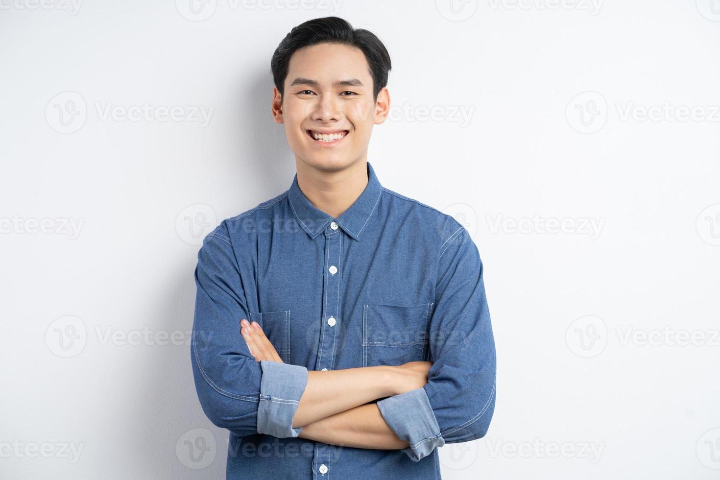 foto van een Aziatische man die met zijn armen over elkaar staat en lacht op een witte achtergrond white