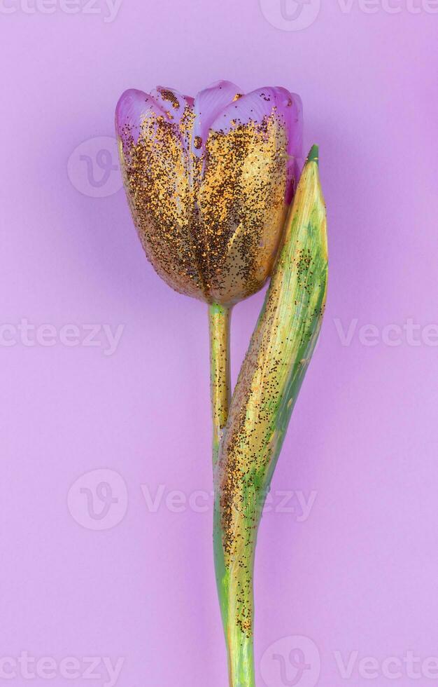 een mooi bloem gedekt met goud verf Aan een roze achtergrond. gouden tulp geïsoleerd. foto