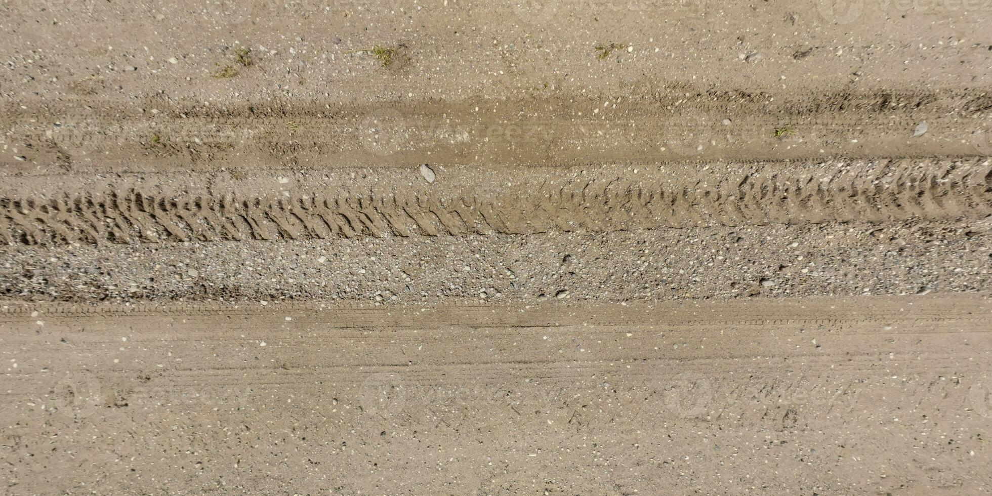 panorama van weg van bovenstaand Aan oppervlakte van grind weg met auto band sporen in platteland foto