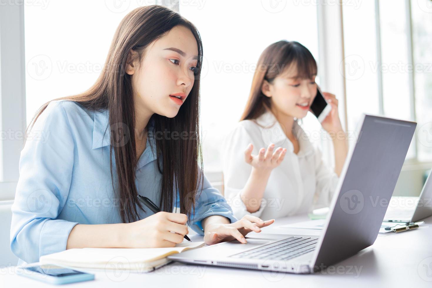 jonge Aziatische vrouw die zich concentreert op het werk gedaan krijgen foto