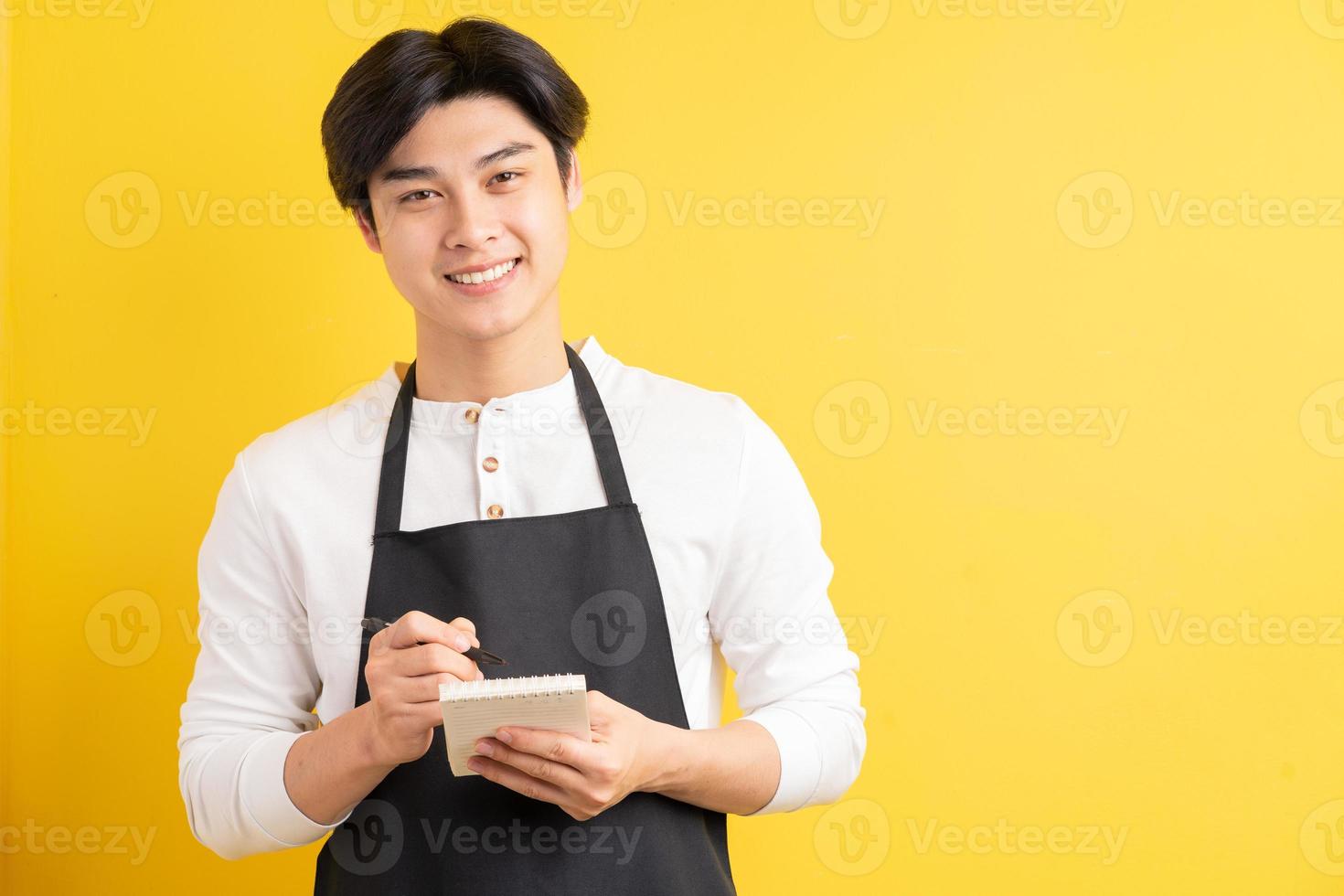 portret van mannelijke kelner die notitieboekje in hand houdt om orde op te nemen foto