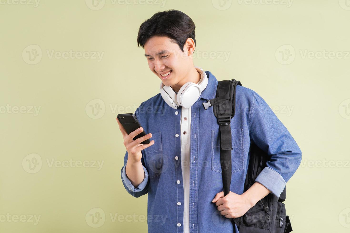 portret van knappe Aziatische student met behulp van slimme telefoon foto