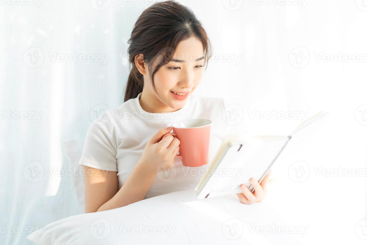 portret van een jong Aziatisch meisje dat een boek leest en koffie drinkt foto