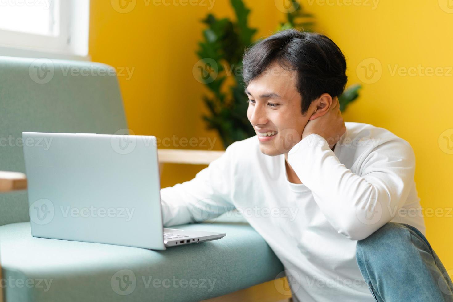 aziatische man zittend op de vloer die een videogesprek voert foto