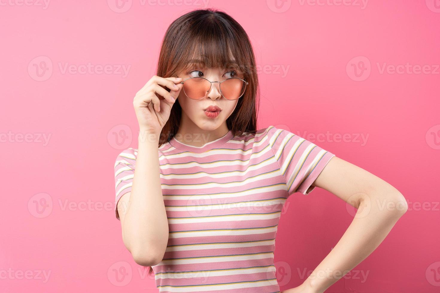afbeelding van een jong Aziatisch meisje met een roze t-shirt op een roze achtergrond foto