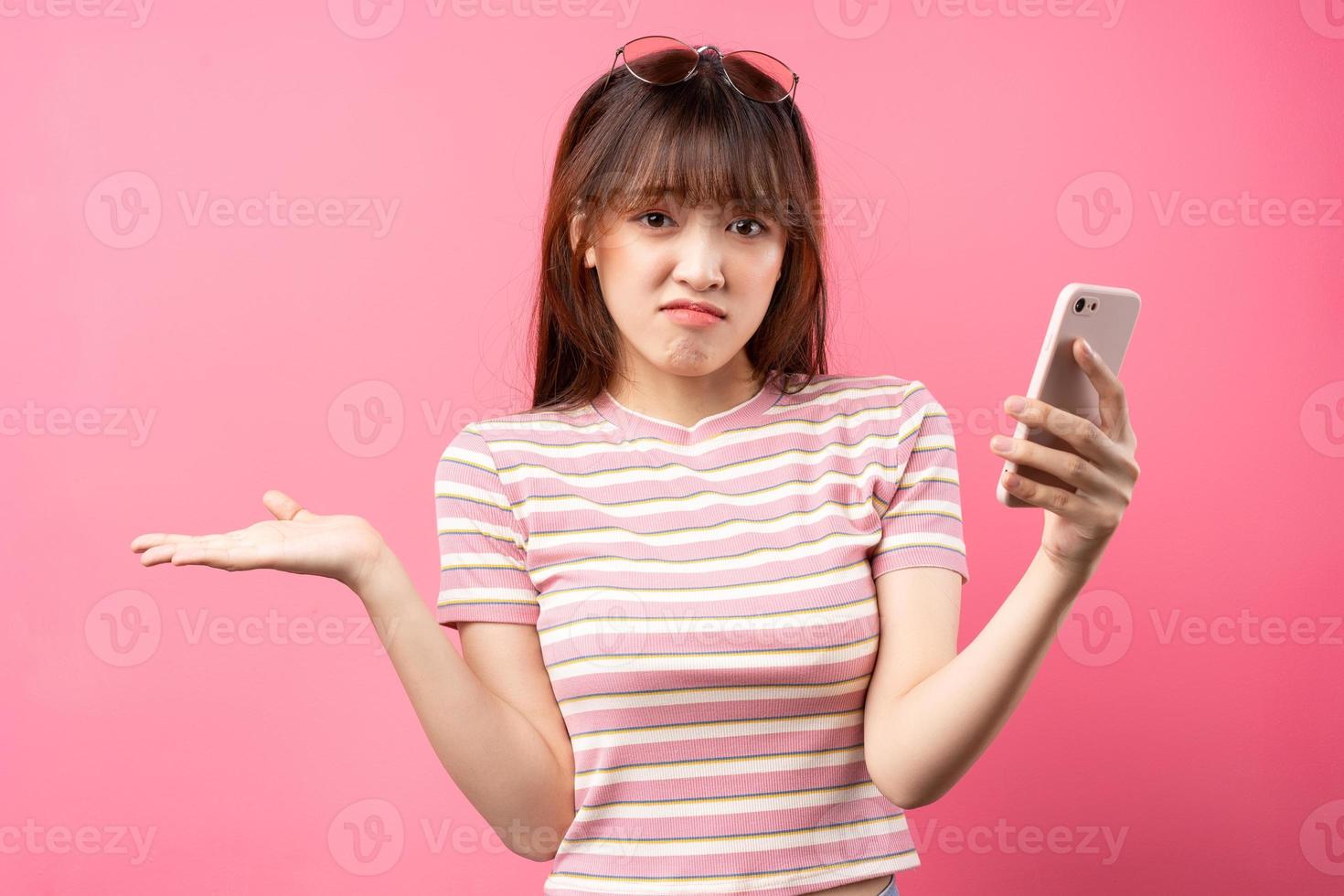 afbeelding van een jong Aziatisch meisje met een roze t-shirt op een roze achtergrond foto