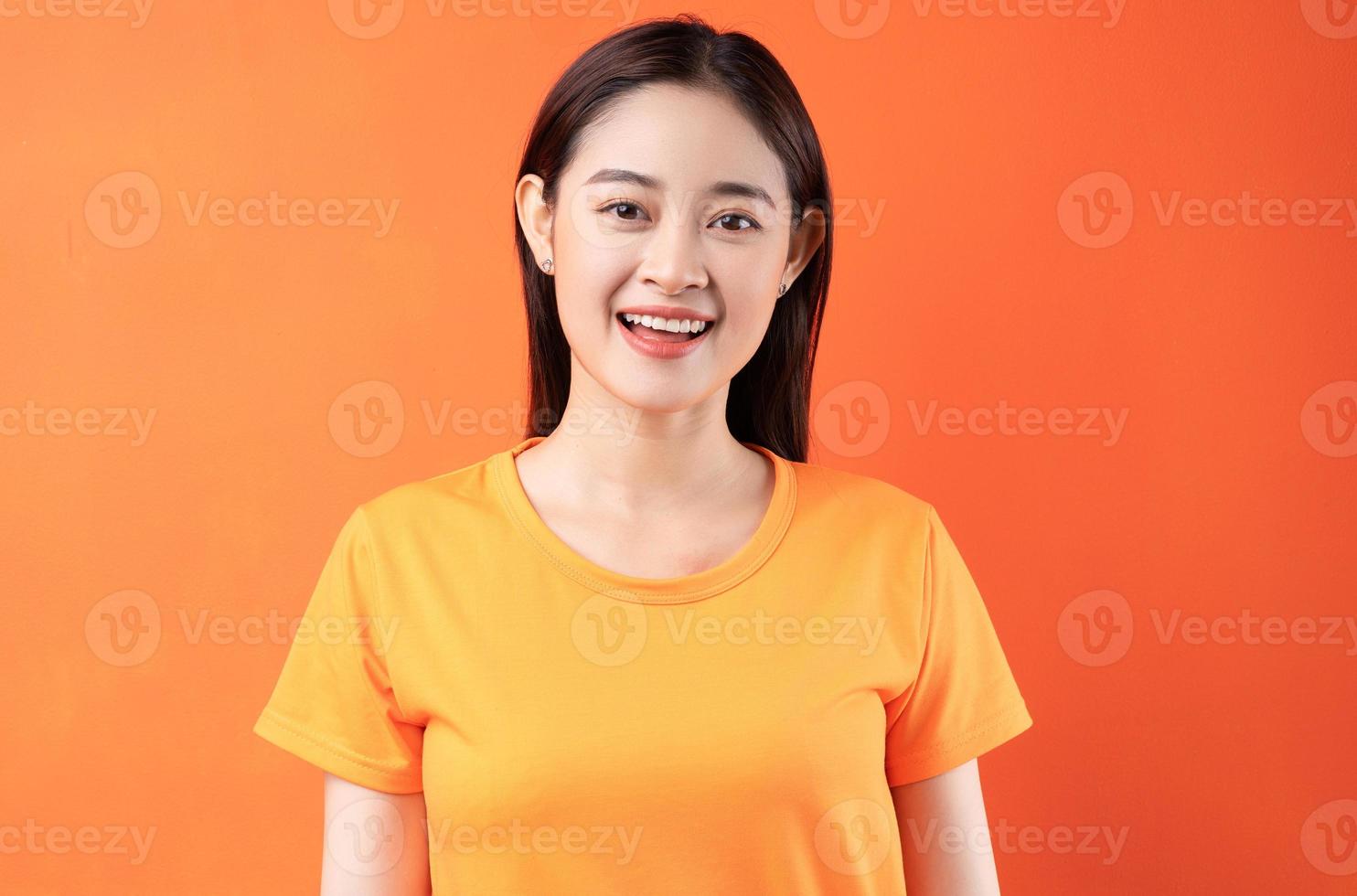 afbeelding van een jonge Aziatische vrouw die een oranje t-shirt draagt op een oranje achtergrond orange foto