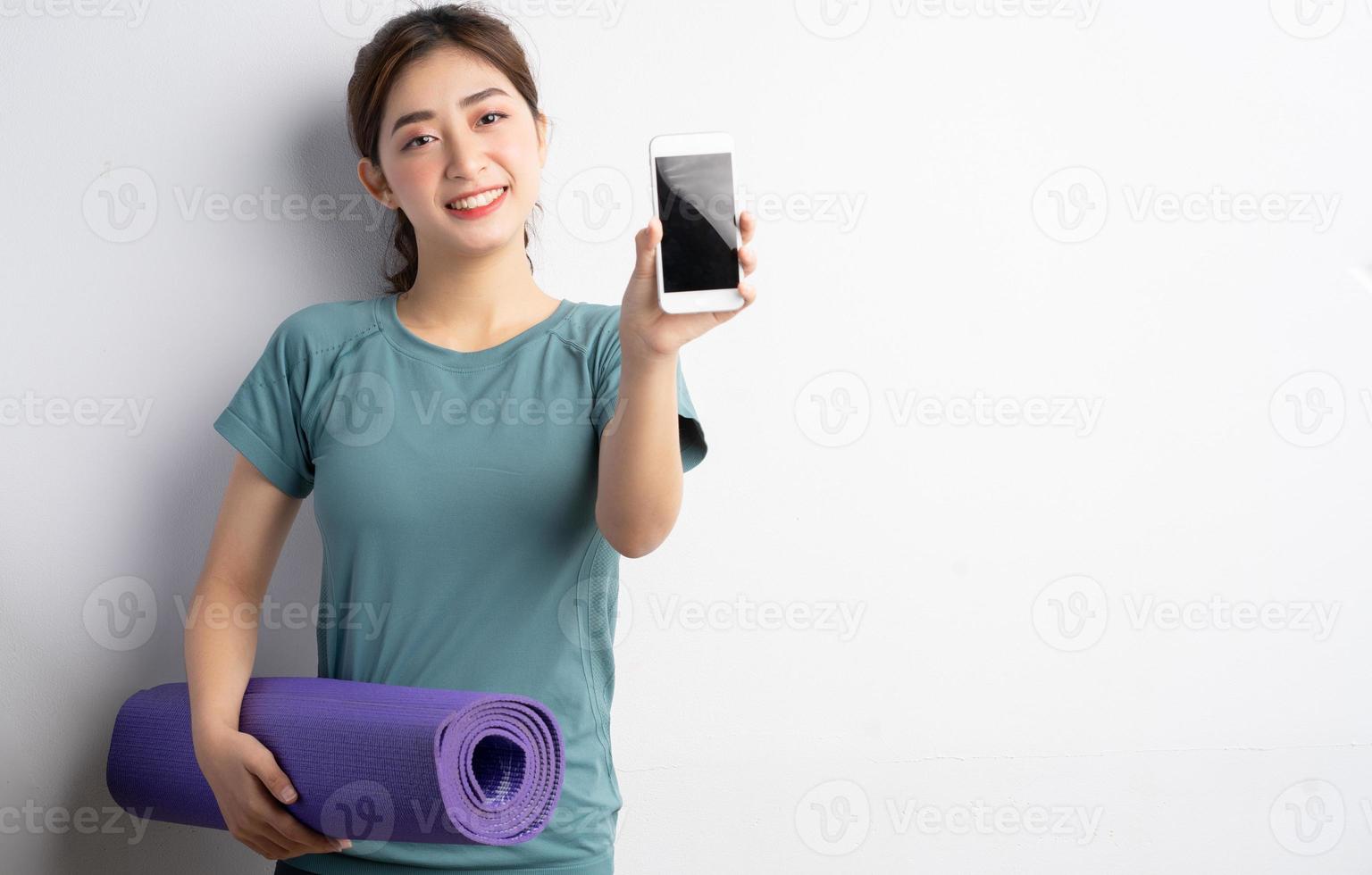 jonge aziatische vrouw die oefening op witte achtergrond doet foto