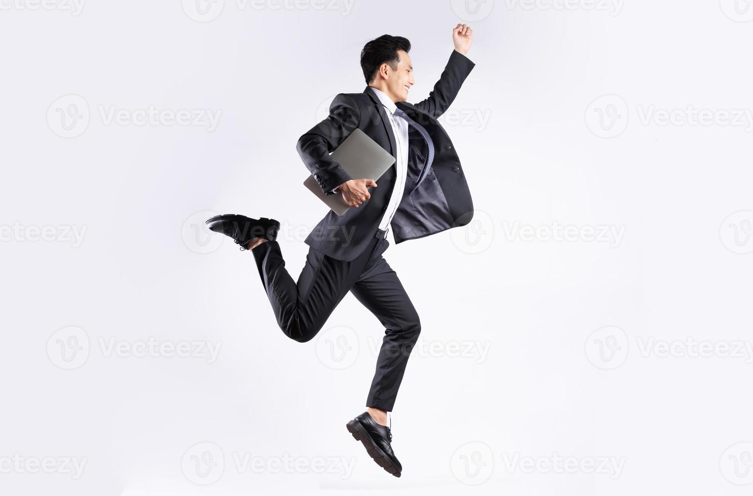 jonge aziatische zakenman die op witte achtergrond springt foto