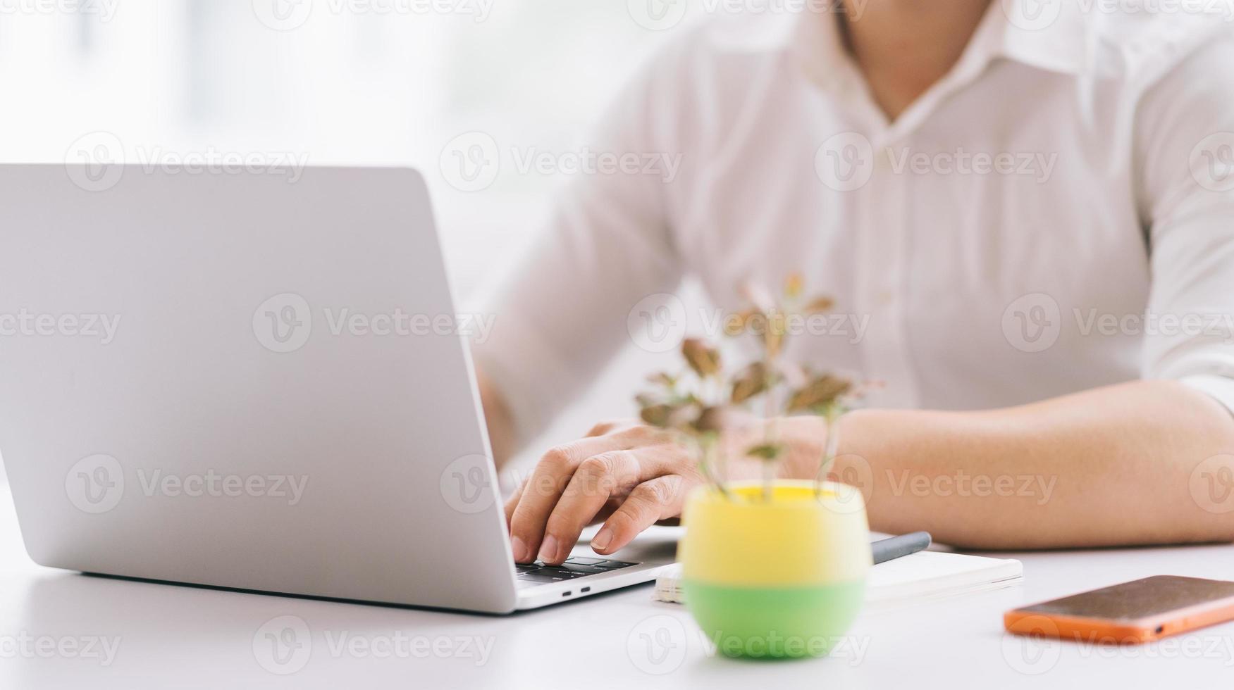 jonge Aziatische zakenman die met laptop op kantoor werkt foto