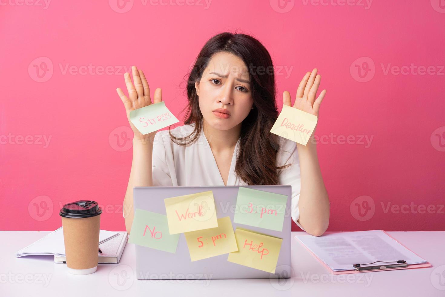 jonge Aziatische zakenvrouw zitten werken met expressie op background foto