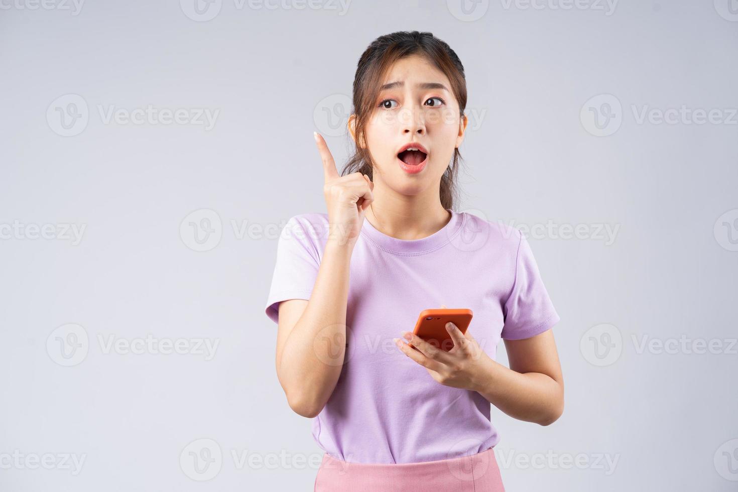 jonge aziatische vrouw die smartphone gebruikt om te brainstormen foto