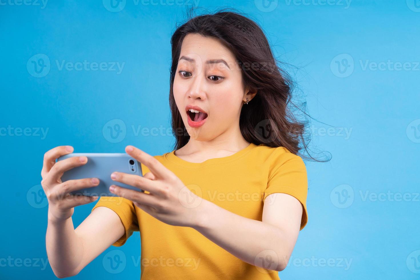mooie aziatische vrouw die een spel speelt op de telefoon foto