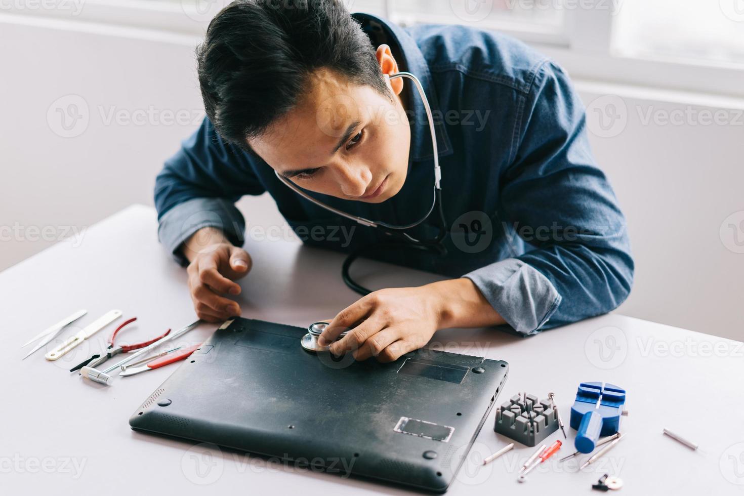 de Aziatische man haalde een kapotte computer tevoorschijn om hem te repareren foto