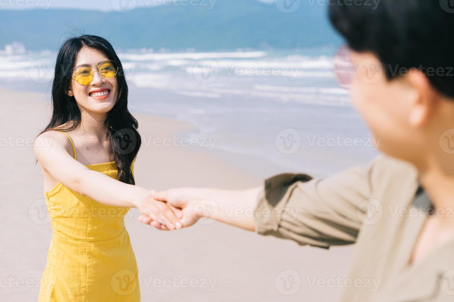 jong Aziatisch paar dat van de zomervakantie op het strand geniet foto