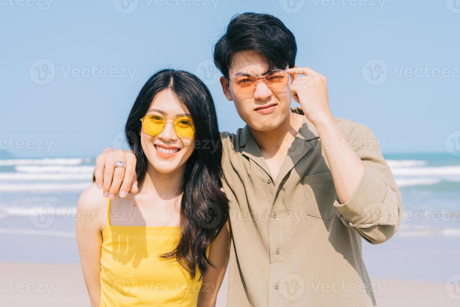 jong Aziatisch paar dat van de zomervakantie op het strand geniet foto