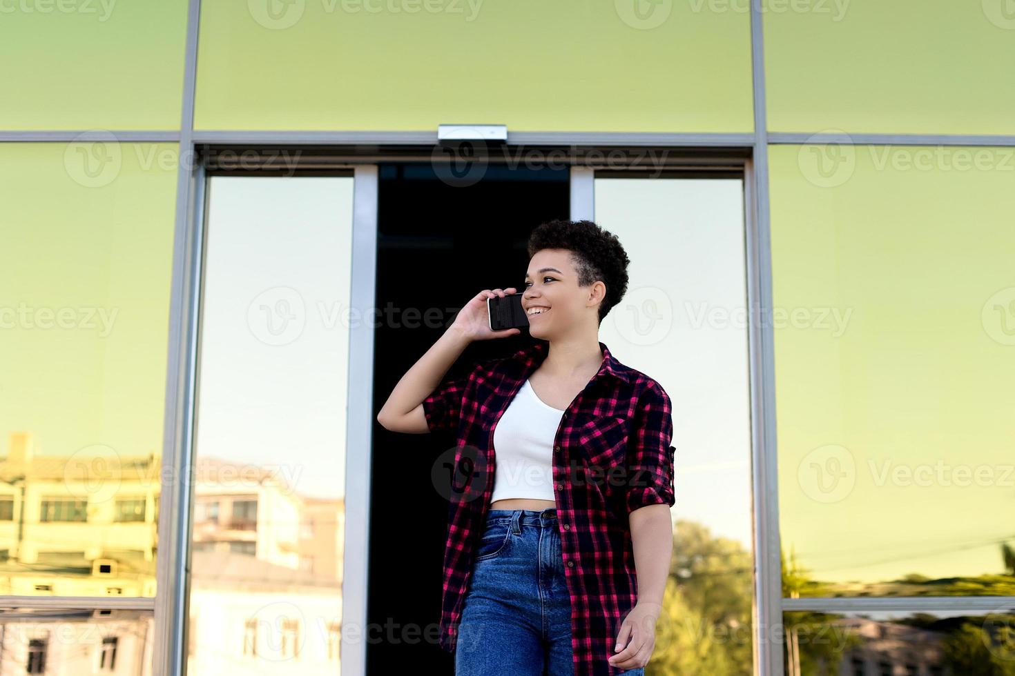 mooie afro-amerikaanse vrouw met kort haar in de zomer op straat foto