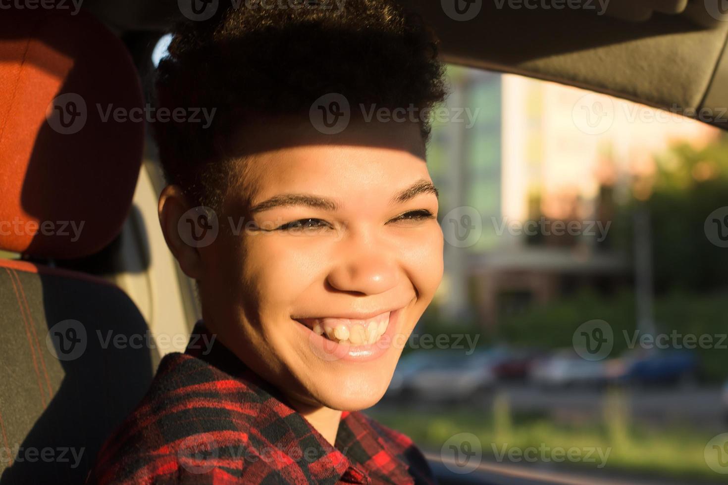 gelukkige en mooie Afro-Amerikaanse vrouw met kort haar in een auto, lifestyle, foto