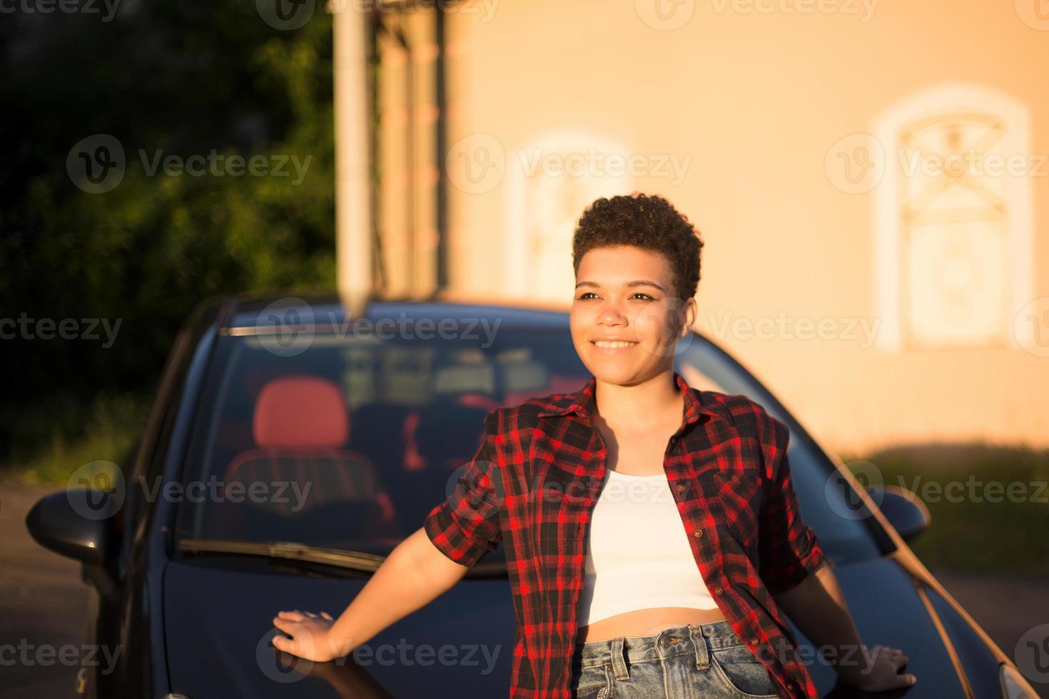 mooie Afro-Amerikaanse vrouw met kort haar in de buurt van de auto, lifestyle, foto