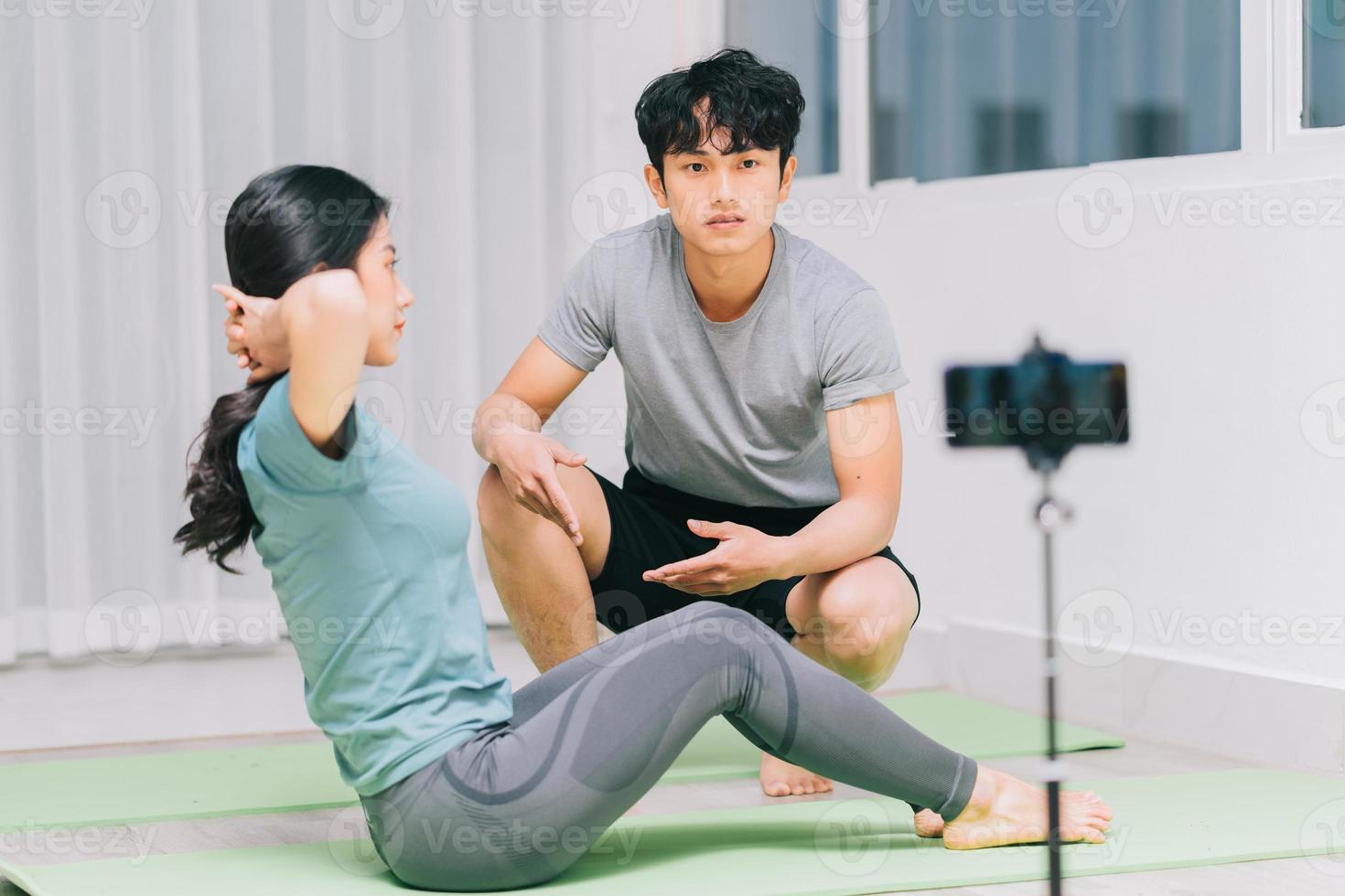 Aziatische personal trainer begeleidt studenten yoga en video-opname om online yoga te onderwijzen foto