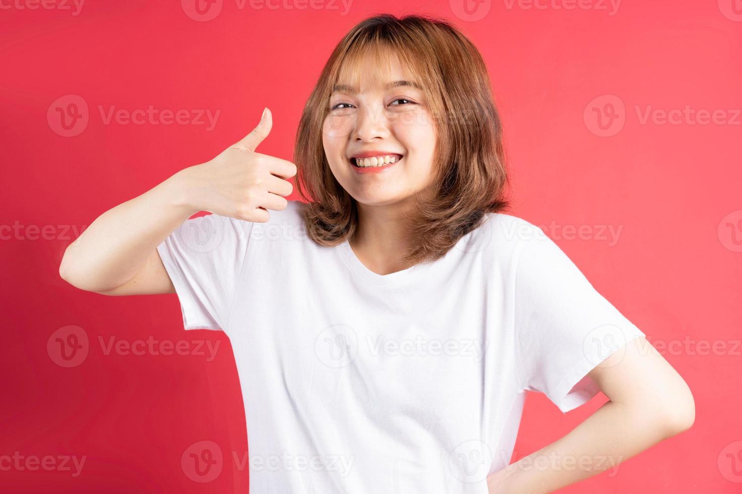 jong Aziatisch meisje met vrolijke gebaren en uitdrukkingen op achtergrond foto