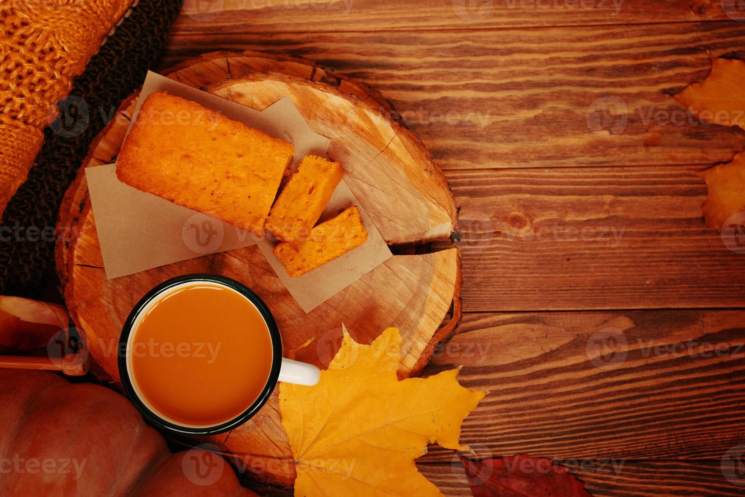 bovenaanzicht van de herfstcompositie met een kopje, een pompoen, een taart en een trui. foto