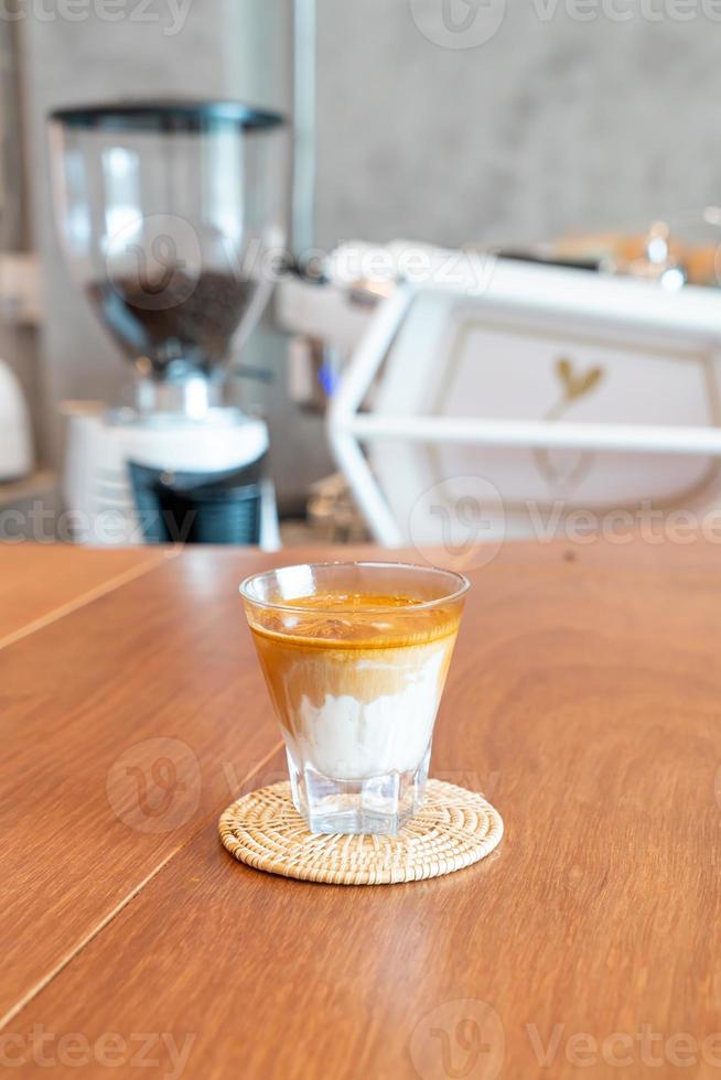vuil koffieglas, of koude melk gegarneerd met hete espressokoffie, in een coffeeshop foto