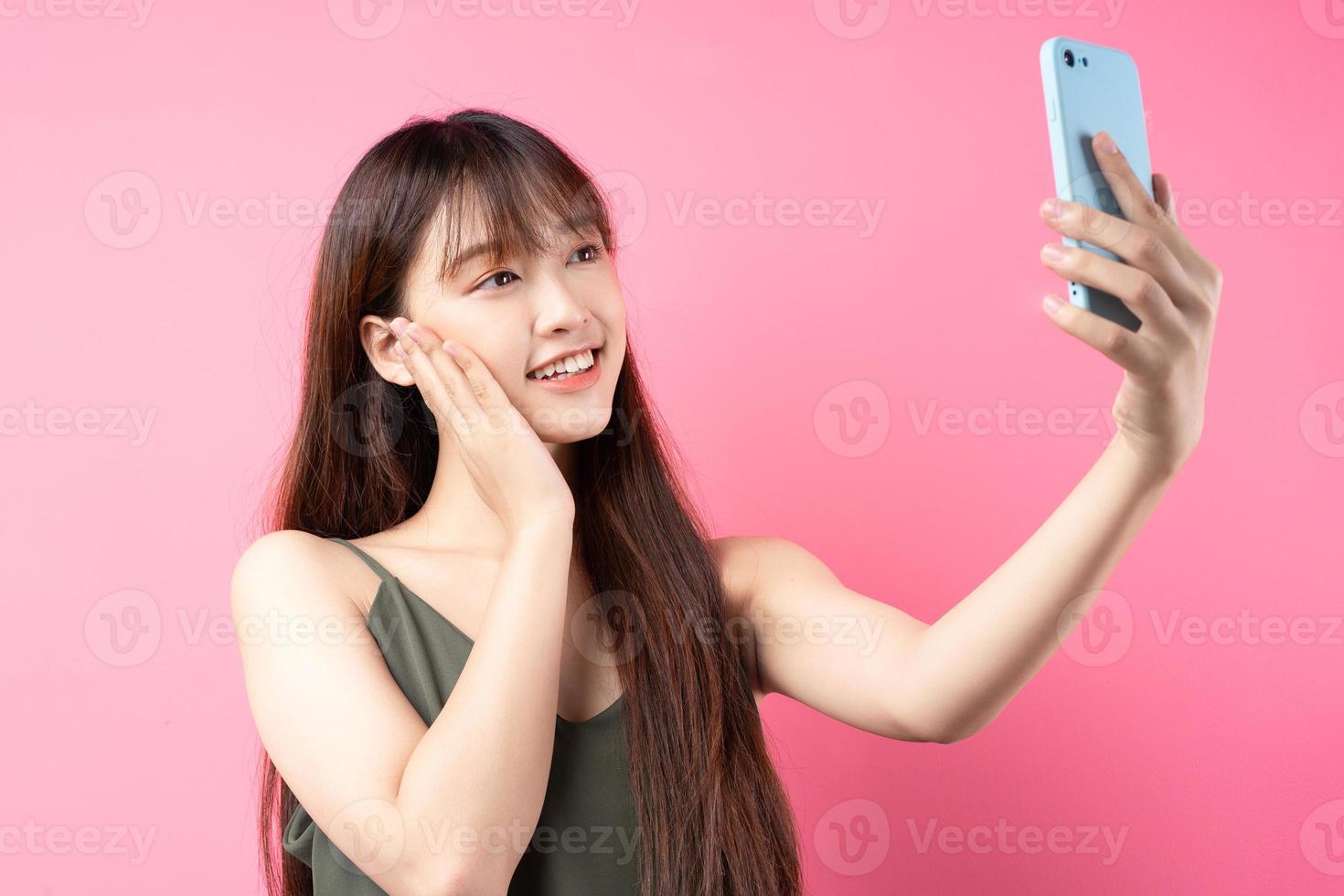 jong Aziatisch meisje poseren op een roze achtergrond foto