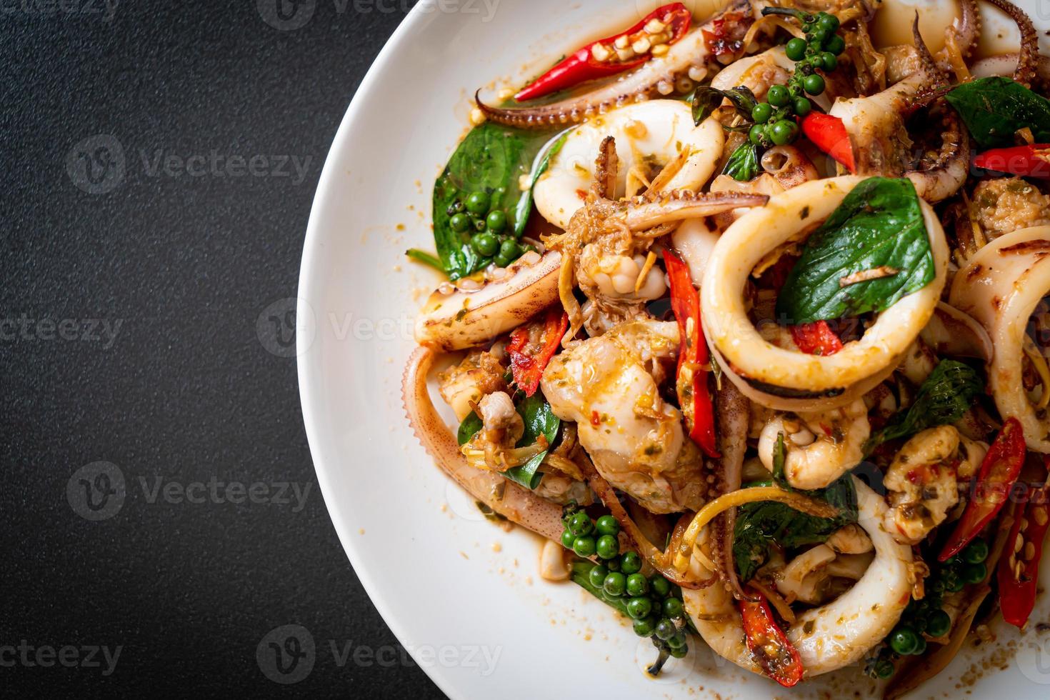roergebakken heilige basilicum met octopus of inktvis en kruid - Aziatisch eten food foto
