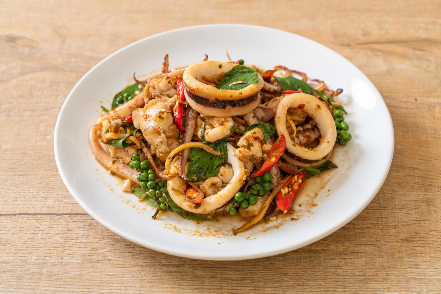 roergebakken heilige basilicum met octopus of inktvis en kruid - Aziatisch eten food foto