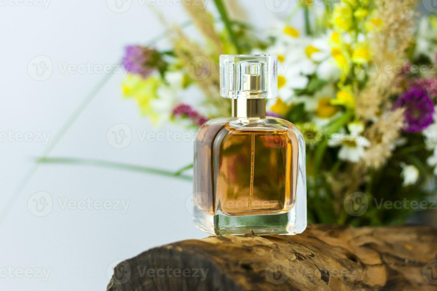een parfum fles Aan de achtergrond van een droog stomp, boom schors en een boeket van wild bloemen. elegant uiterlijk, lay-out, persoonlijkheid. banier, een plaats voor de tekst. foto