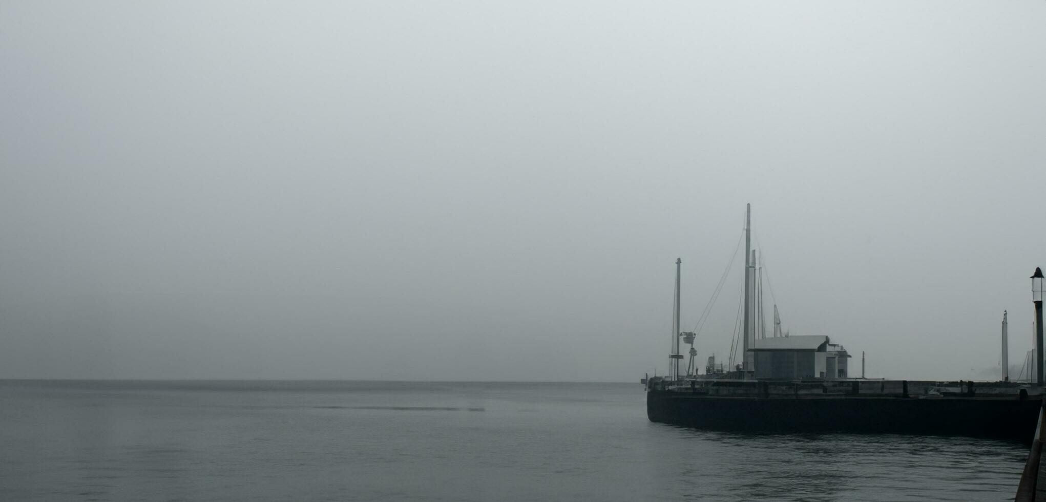 de pier de waterkant eng en eenzaam achtergrond waterkant smog donker toon beeld foto