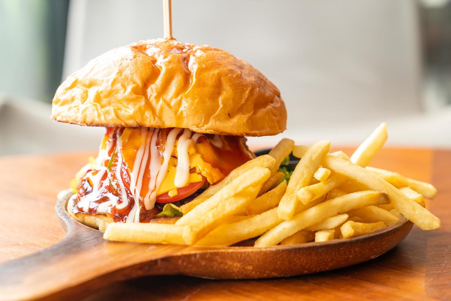 runderburger met kaas en saus op houten plaat foto