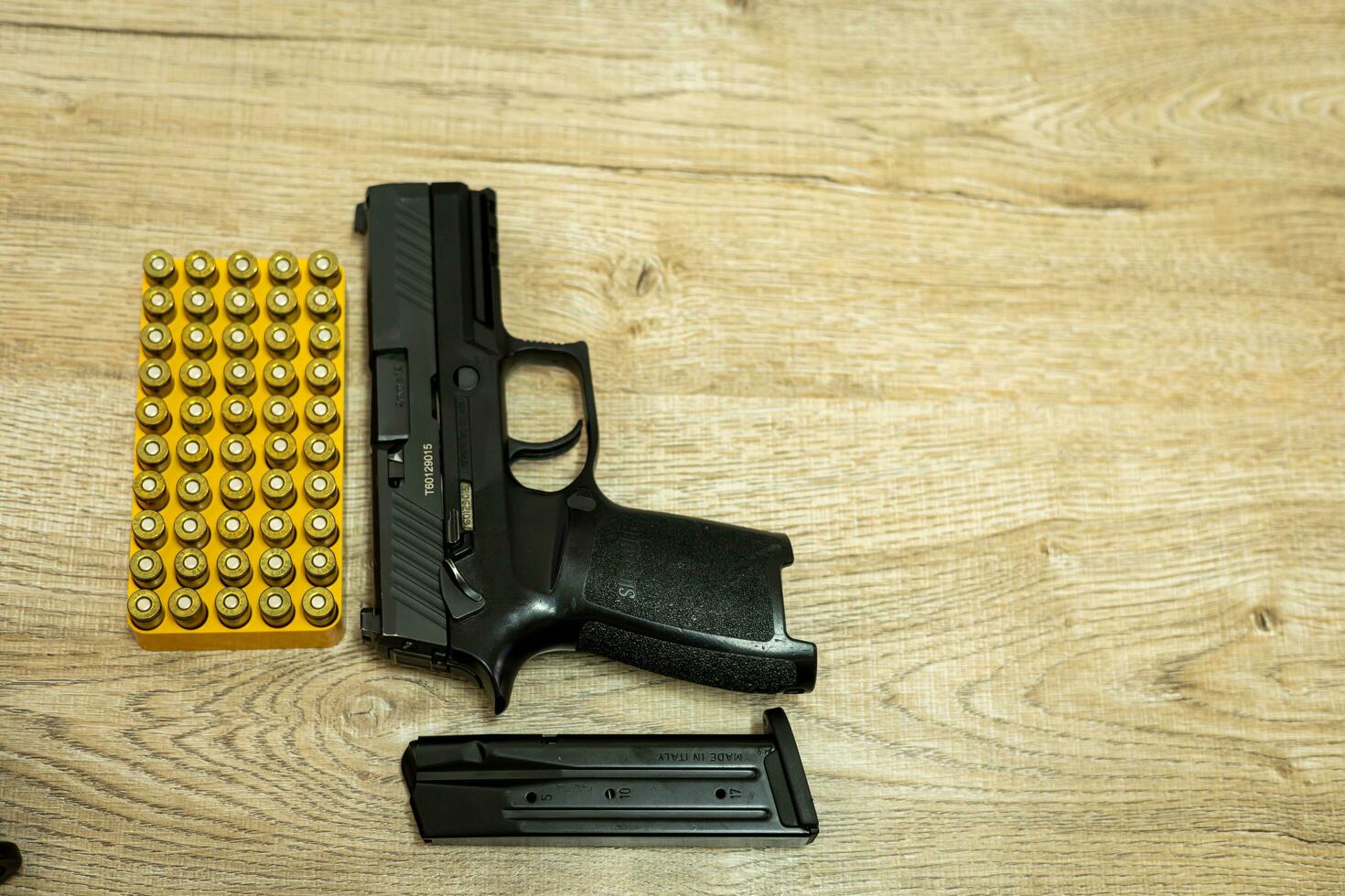 handgeweer en kogels en mags aan het liegen Aan een houten tafel foto